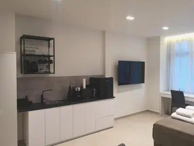 a kitchen with a counter with a sink and a tv at Evripidou Experience - The Suite in Athens
