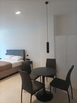 a bedroom with a table and chairs and a bed at Evripidou Experience - The Suite in Athens