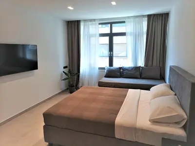 a bedroom with a large bed and a couch at Evripidou Experience - Triple Suite in Athens