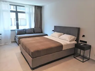 a bedroom with a bed and a couch in it at Evripidou Experience - Triple Suite in Athens