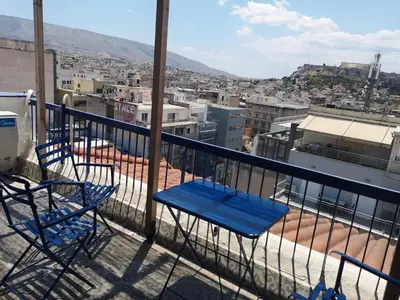 a balcony with chairs and a view of a city at Evripidou Experience - Triple Suite in Athens