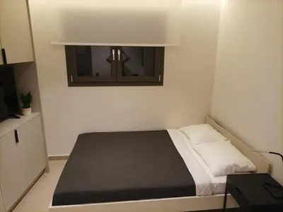 a small bedroom with a bed and a window at Evripidou Experience - The smart double C in Athens