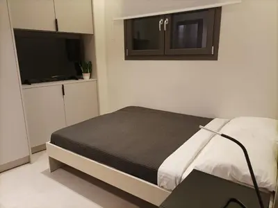a bedroom with a bed with a desk and a tv at Evripidou Experience - The smart double C in Athens