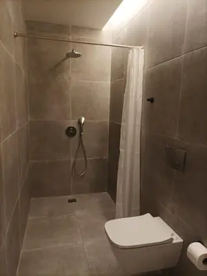 a bathroom with a shower with a toilet and a shower curtain at Evripidou Experience - The smart double C in Athens