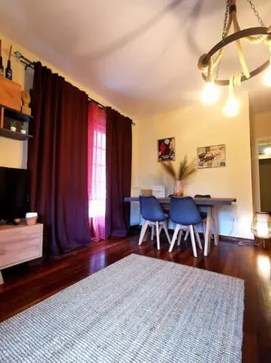 a living room with a table and chairs and a rug at Lucy's apartment in Athens