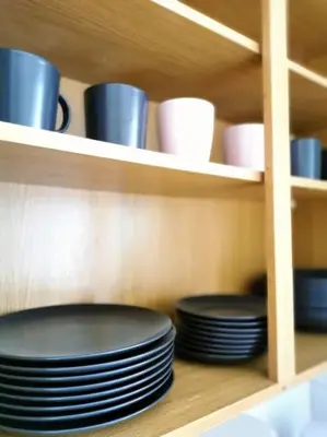 a cabinet filled with plates and cups and bowls at Lucy's apartment in Athens