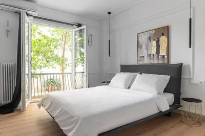a bedroom with a large white bed and a large window at Athenian Postmodern Gem in Athens
