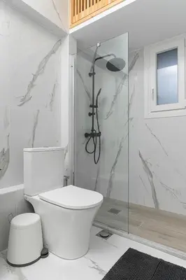 a white bathroom with a toilet and a shower at Athenian Postmodern Gem in Athens