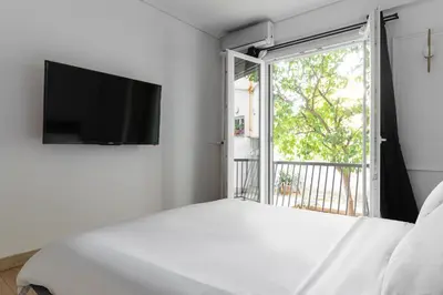 a bedroom with a bed and a tv and a window at Athenian Postmodern Gem in Athens