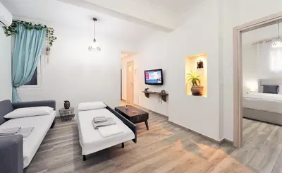 a white living room with a couch and a table at Bella Ciao Guest House in Athens