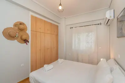 a bedroom with a white bed and a window at Renovated Lovely Apt next to Marina Flisvos in Athens