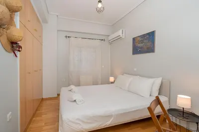 a bedroom with a white bed with two towels on it at Renovated Lovely Apt next to Marina Flisvos in Athens