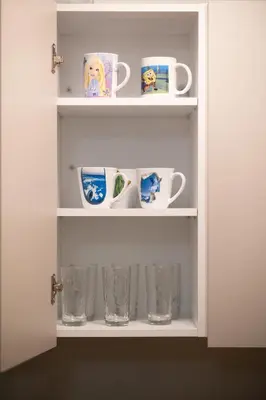 a white cabinet with cups and glasses on it at Athenian Dream Apartment-Spacious Comfortable & Luxurious in a real Athenian neighborhood in Athens
