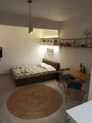 a bedroom with a bed and a wooden table and a tableablish at Mosaics Athens easystay in the Historical centre in Athens