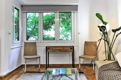 a living room with a table and two chairs and a window at Kolonaki Jewel 1st floor feel like home properties in Athens