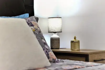 a bedroom with a bed with a table with a lamp at Kolonaki Jewel 1st floor feel like home properties in Athens