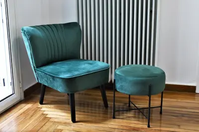 a green chair and a stool in front of a radiator at Kolonaki Jewel 1st floor feel like home properties in Athens