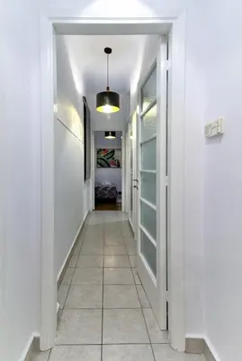 a hallway with white walls and a tile floor at Kolonaki Jewel 1st floor feel like home properties in Athens
