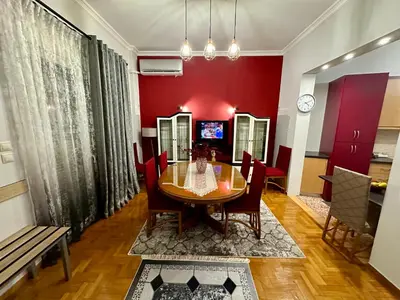 a dining room with a table and a red wall at Bratis House Athens in Athens