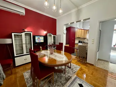 a living room with a wooden table and red walls at Bratis House Athens in Athens