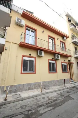 a yellow and red building with a balcony at Bratis House Athens in Athens