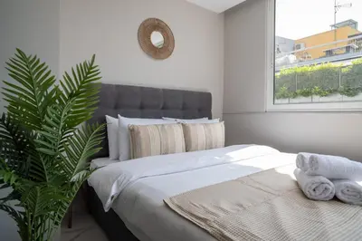 a bedroom with a bed with a plant and a window at Heart Of Athens Apartments in Athens