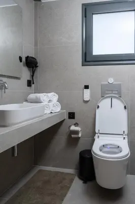 a bathroom with a toilet and a sink and a window at Heart Of Athens Apartments in Athens