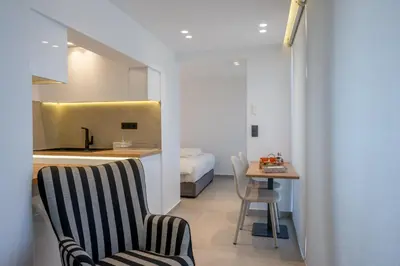 a room with a bed and a table and chairs at Heart Of Athens Apartments in Athens