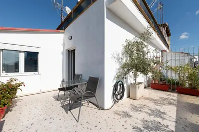 a patio with a table and chairs on a building at Acropolis view Penthouse by WeHost Athens in Athens