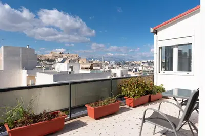 a balcony with plants and a table and chairs at Acropolis view Penthouse by WeHost Athens in Athens