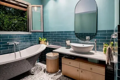 a bathroom with a tub and a sink and a mirror at Secret Garden Downtown in Athens