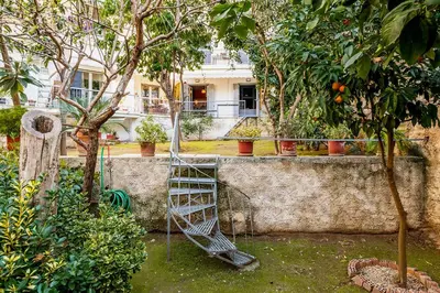 a garden with a spiral staircase next to some trees at Secret Garden Downtown in Athens
