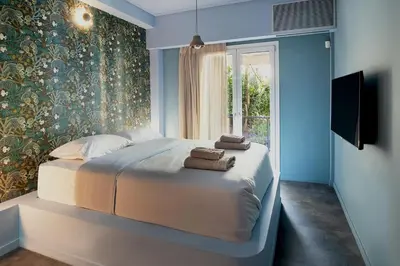 a bedroom with a large bed with towels on it at Secret Garden Downtown in Athens