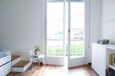 a white room with a door and a table at ViLLaRa: Style, Hospitality & Design (City Center) in Athens