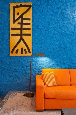 an orange couch in a room with a blue wall at Architect designed studio with green rooftop! EP7R in Athens