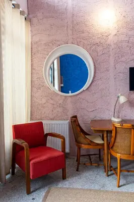 a room with a chair and a table and a mirror at Architect designed studio with green rooftop! EP7R in Athens