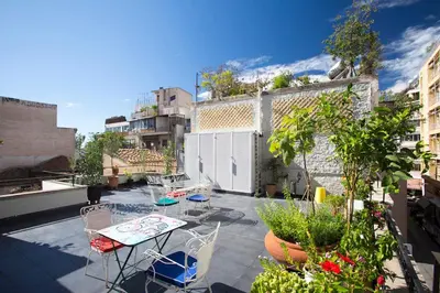 a patio with chairs and tables on a balcony at Architect designed studio with green rooftop! EP7R in Athens
