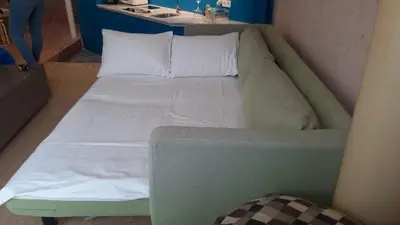 a bed with white sheets and pillows in a room at Architect designed studio with green rooftop! EP7L in Athens