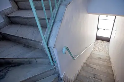 a staircase in a building with a metal hand rail at Architect designed studio with green rooftop! EP7L in Athens