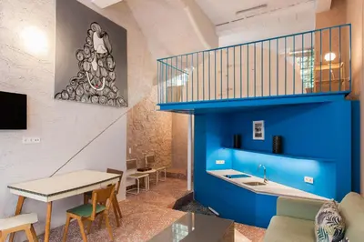 a kitchen and dining room with a blue wall at Architect designed studio with green rooftop! EP7L in Athens