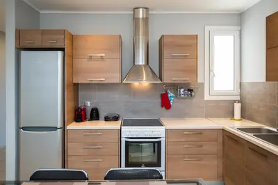 a kitchen with wooden cabinets and a stove top oven at Spacious1 Bedroom Flat In The Heart Of Athens in Athens
