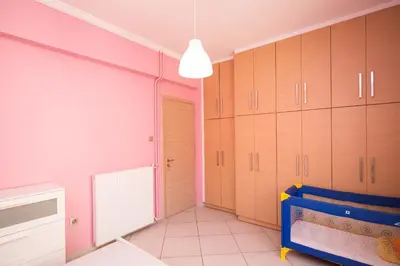 a kitchen with pink and white cabinets and a blue crib at Spacious1 Bedroom Flat In The Heart Of Athens in Athens