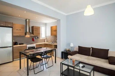a kitchen and living room with a couch and a table at Spacious1 Bedroom Flat In The Heart Of Athens in Athens