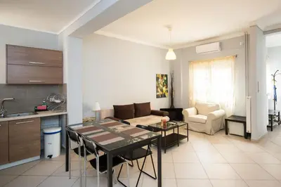 a kitchen and living room with a table and a couch at Spacious1 Bedroom Flat In The Heart Of Athens in Athens