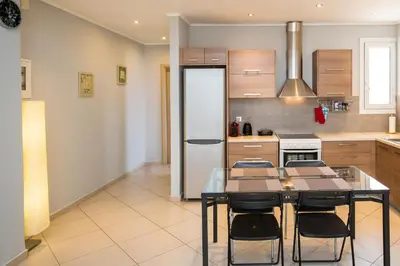 a kitchen with a table with chairs and a refrigerator at Spacious1 Bedroom Flat In The Heart Of Athens in Athens
