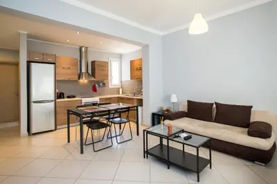 a living room with a couch and a kitchen at Spacious1 Bedroom Flat In The Heart Of Athens in Athens