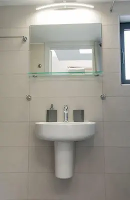 a white bathroom with a sink and a mirror at Athens Syntagma Studio in Athens