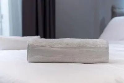 a white towel sitting on top of a bed at Athens Syntagma Studio in Athens