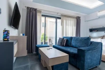 a living room with a blue couch and a table at Athens Syntagma Studio in Athens