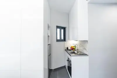 a white kitchen with a sink and a refrigerator at Athens Syntagma Studio in Athens
